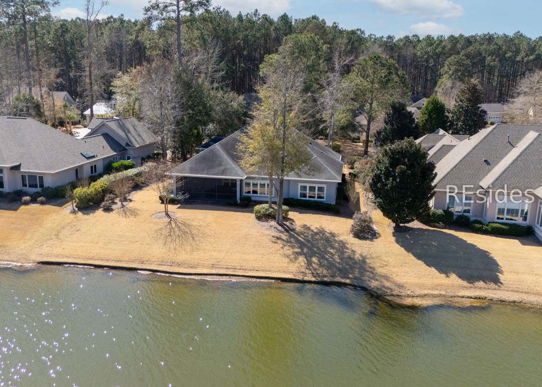 Drone aerial showing 40 Catamaran's full back elevation with the screened lanai facing directly onto the lagoon, the property edge running right to the water line
